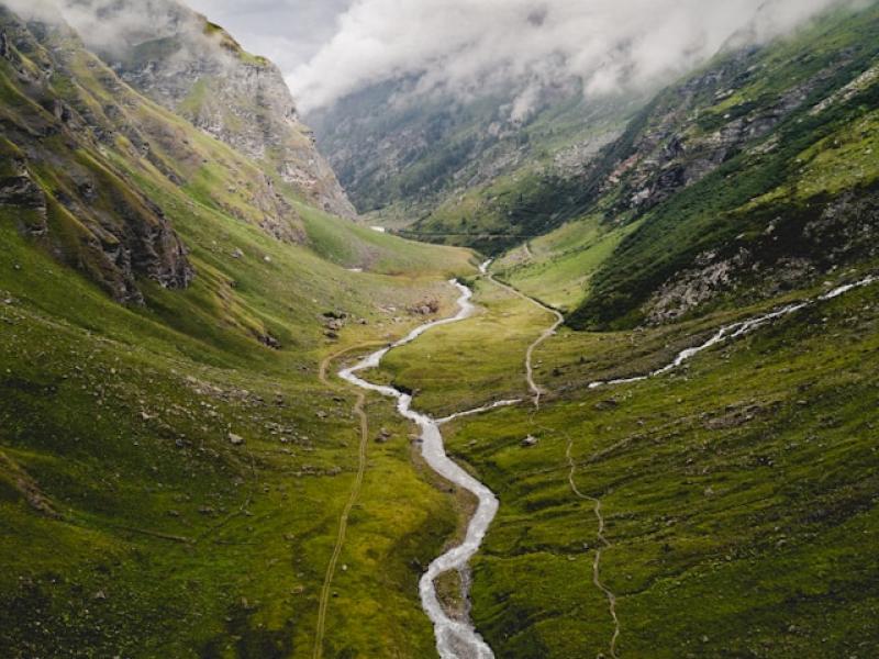green valley grass river grey sky